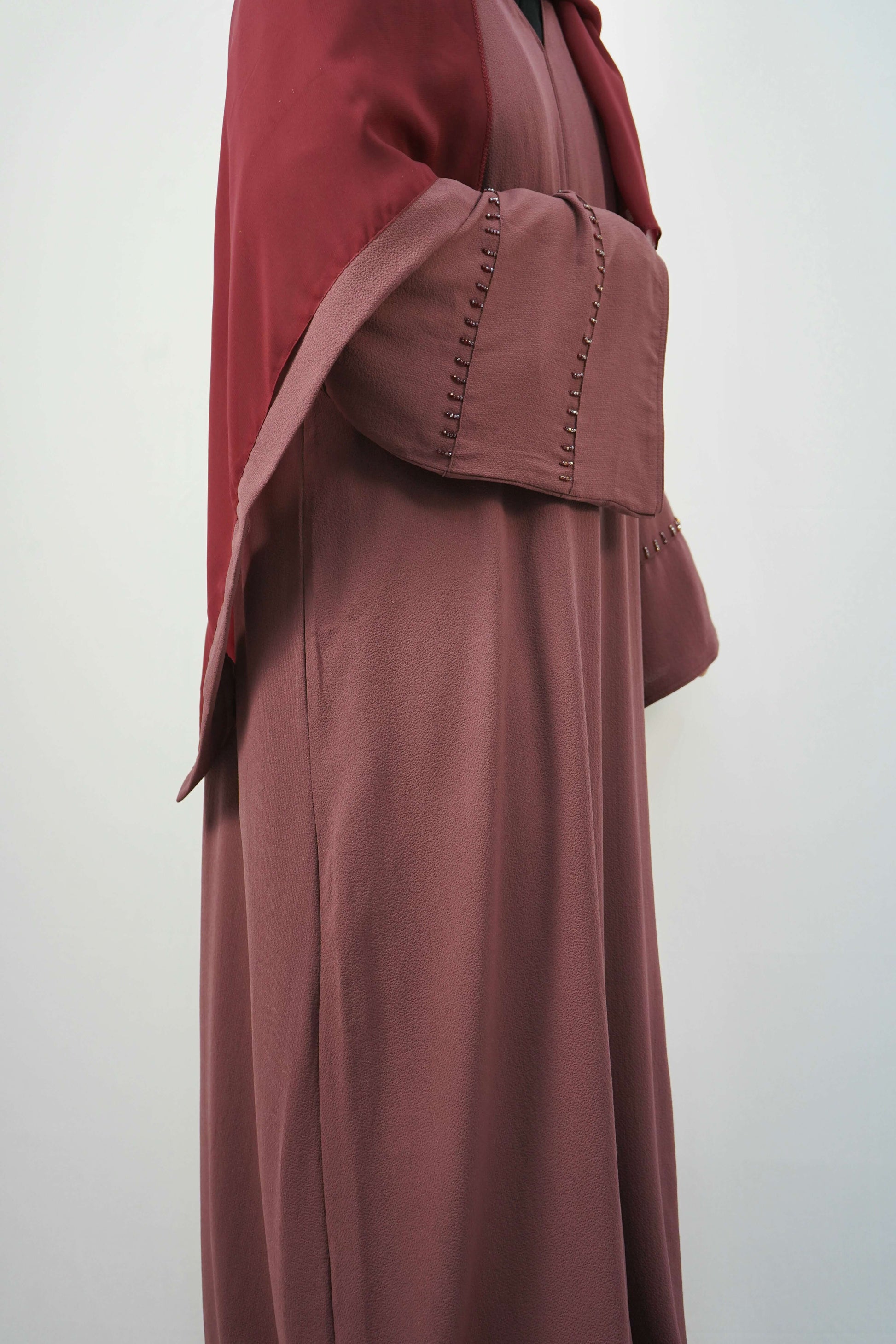 A side view of the Korean Bubble Abaya in Old Mauve, showing the elegant flow of the fabric and the unique studded sleeves.