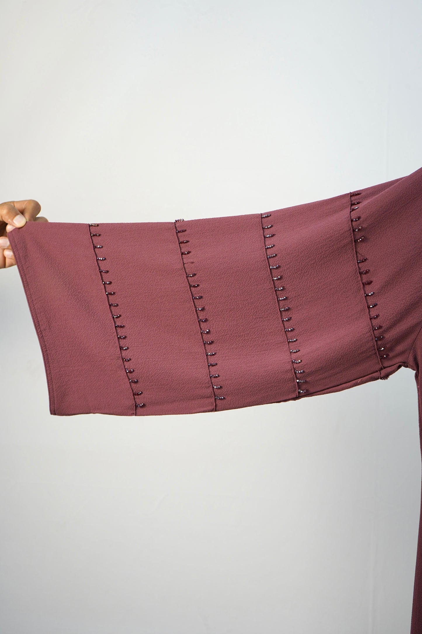 A detailed close-up of the unique studded design on the sleeves of the korean bubble abaya.