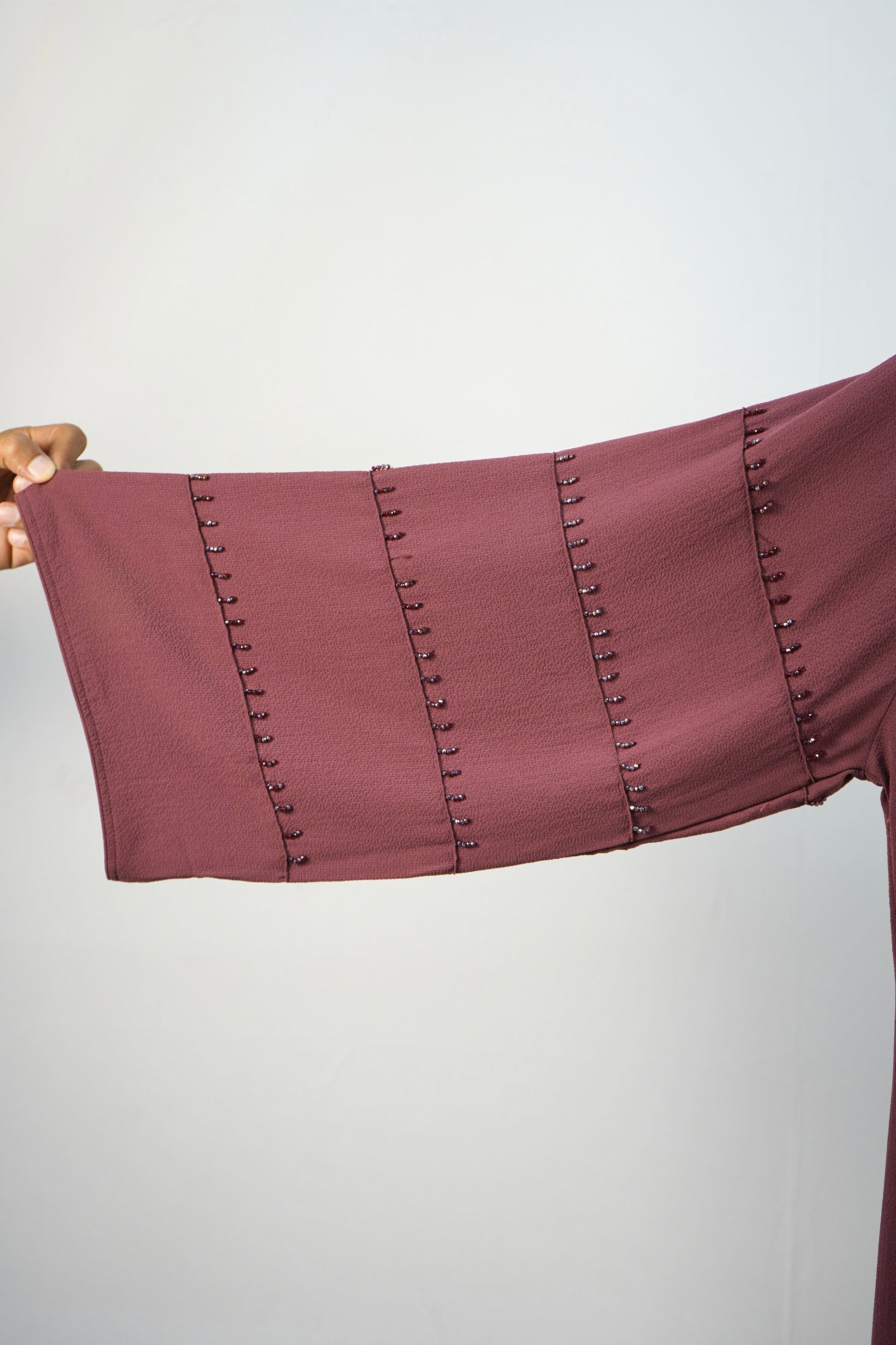 A detailed close-up of the unique studded design on the sleeves of the korean bubble abaya.