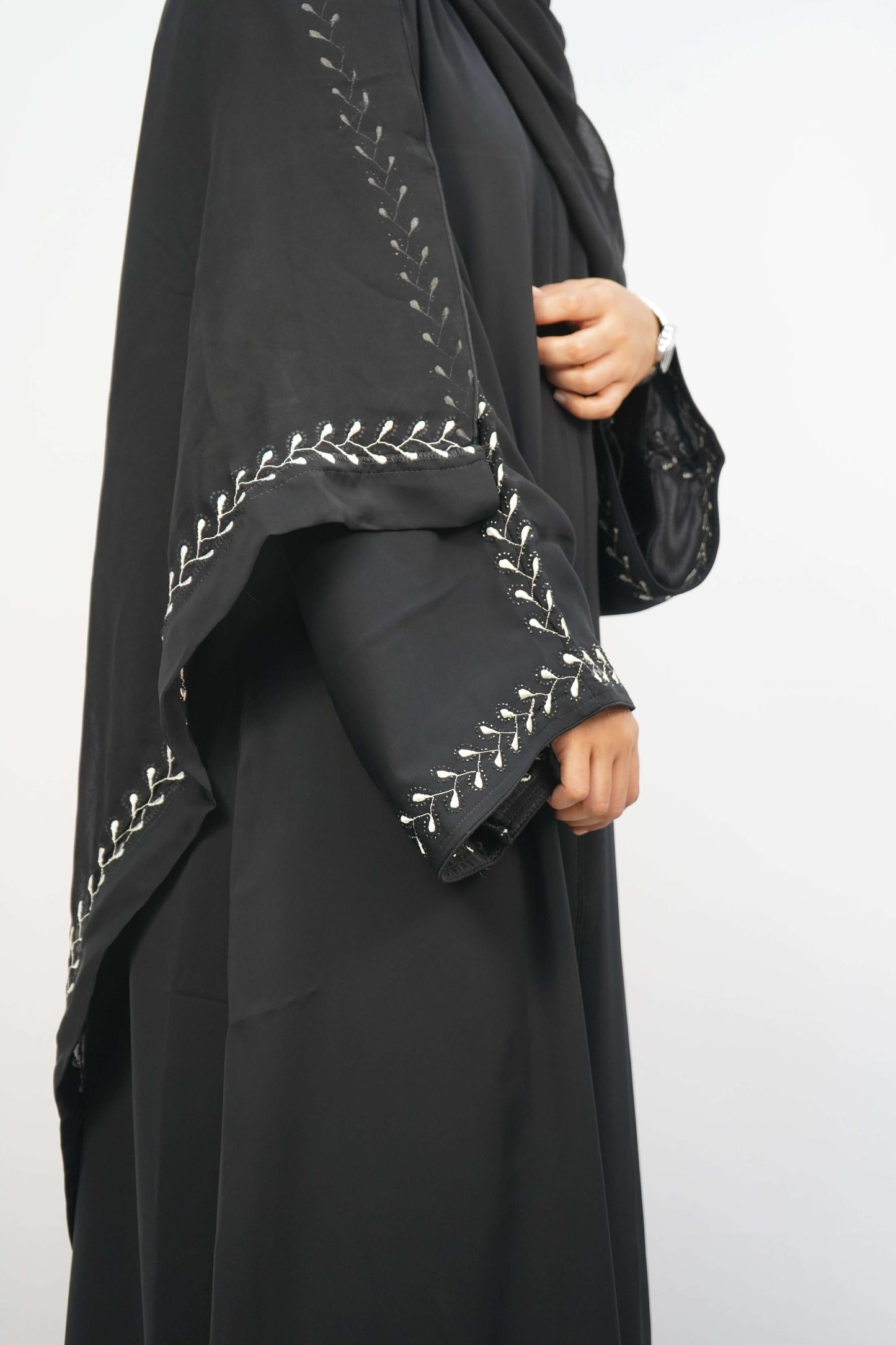 A side view of a person wearing the dusty purple Korean Nidha Abaya, showcasing the flowing silhouette and embroidery on the sleeve.
