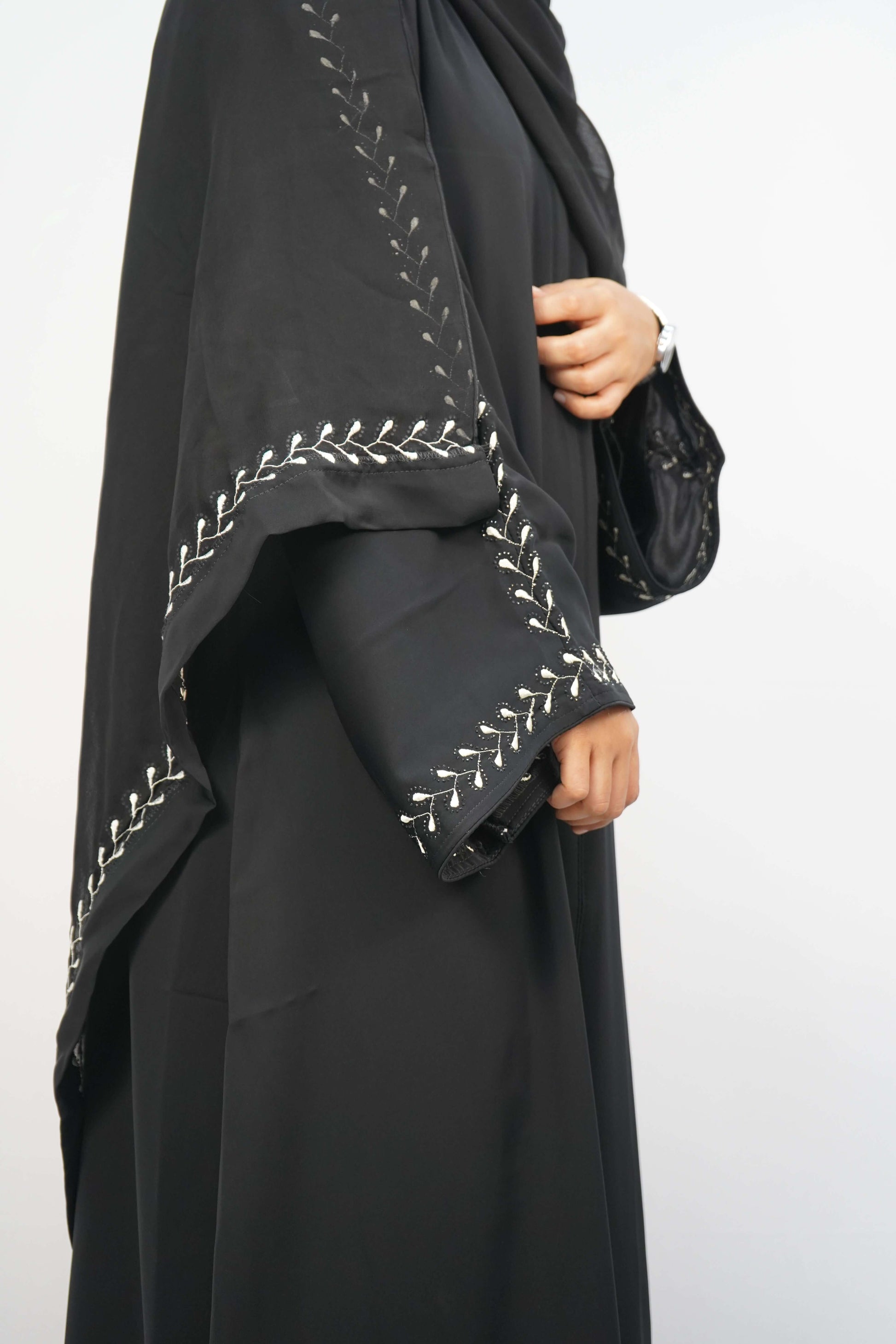 A side view of a person wearing the dusty purple Korean Nidha Abaya, showcasing the flowing silhouette and embroidery on the sleeve.
