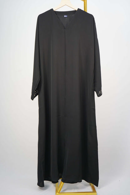 A full shot of the black Korean Nidha Abaya hanging, highlighting the V-neck and and the flowing fabric.