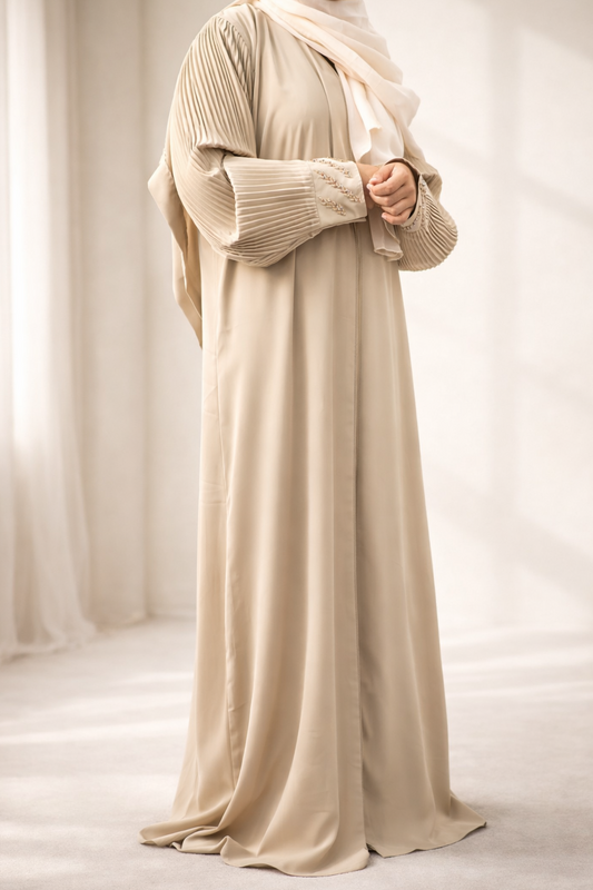 A model wearing the Korean Alqa Nidha Abaya, showcasing the pleated sleeves and matching light beige hijab.