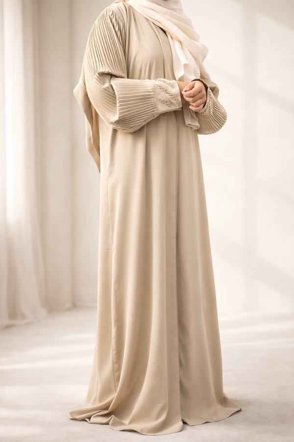 A model wearing the Korean Alqa Nidha Abaya, showcasing the pleated sleeves and matching light beige hijab.