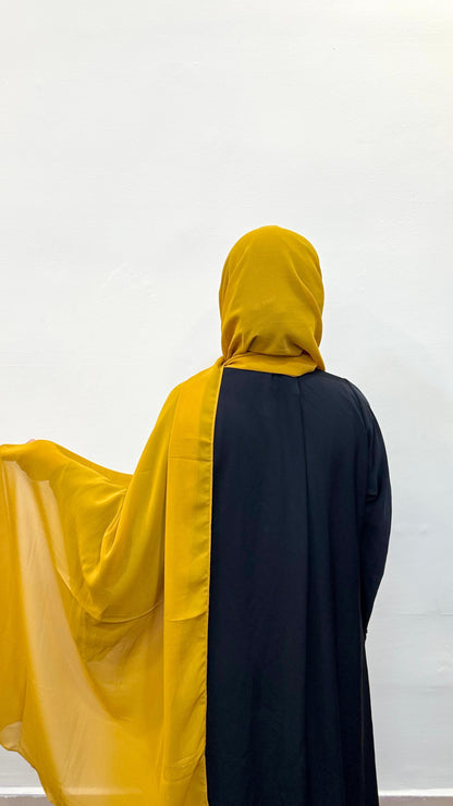 Flowy mustard chiffon scarf captured from behind.