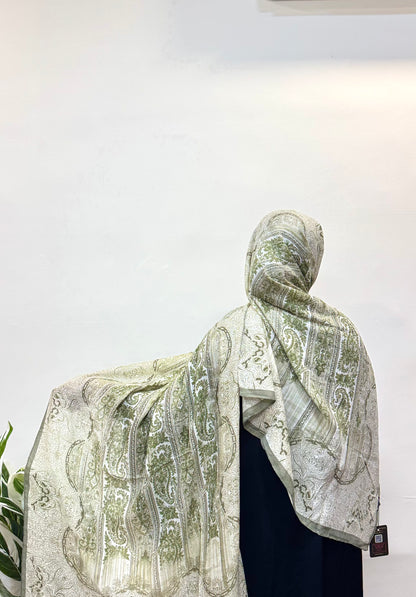 Printed pashmina hijab in sage green, worn modestly.