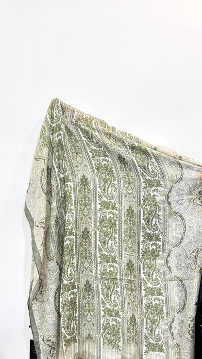 Detailed fabric view of sage green pashmina hijab with print.