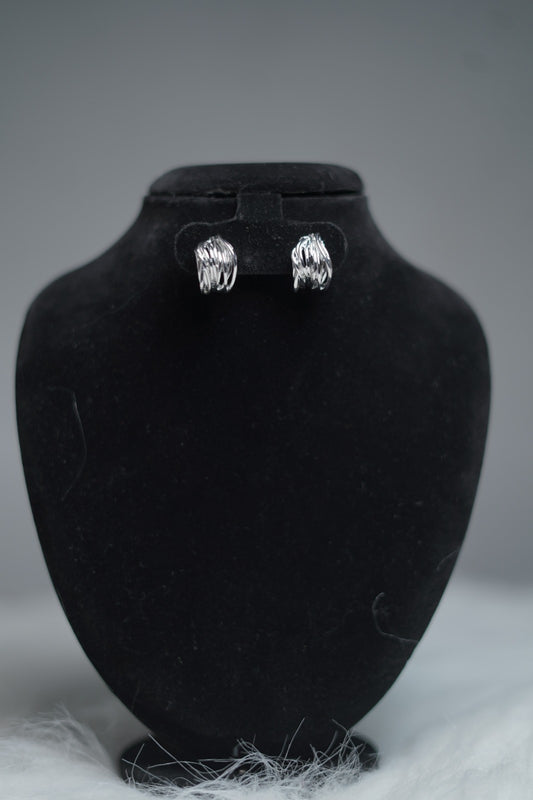 Sculpted silver hoops displayed on earring stand.