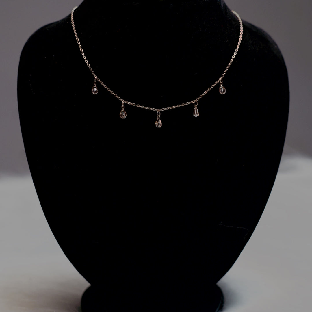Rose gold stone drop chain necklace with five clear crystal teardrops.