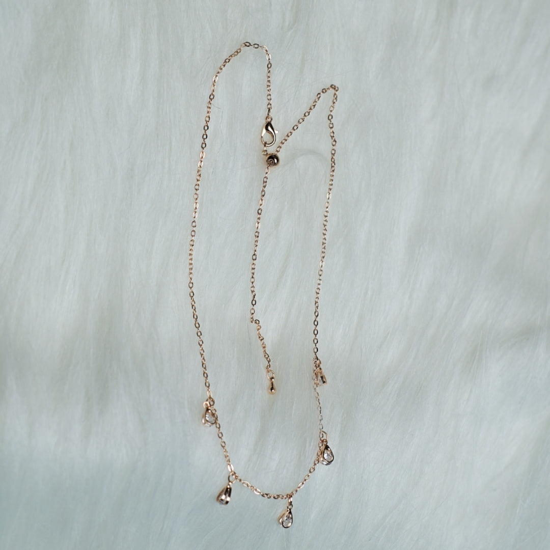 Rose gold stone drop chain necklace with five clear crystal teardrops.