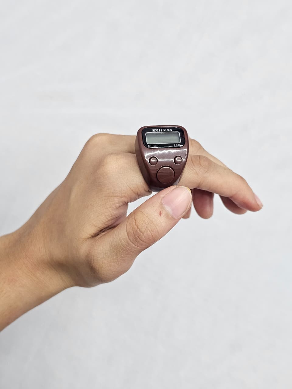 Digital LED tasbeeh counter in brown plastic with reset and count buttons.