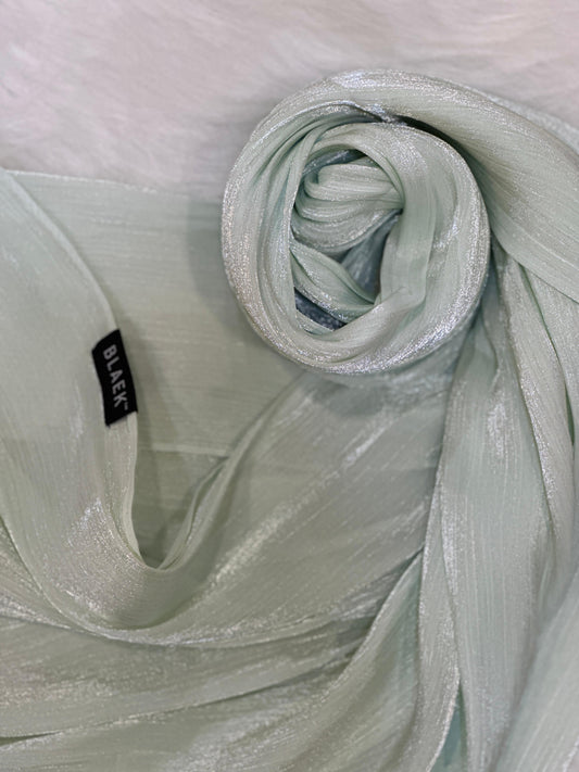 Elegant shimmer hijab in tea green, styled in a swirl to show shine and structure.