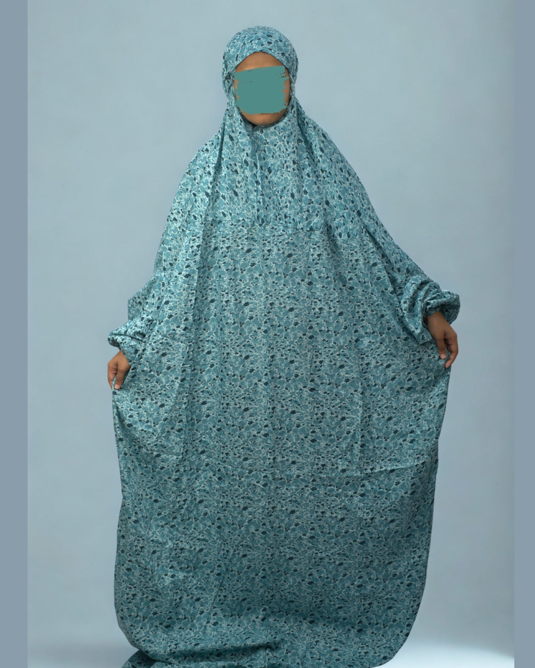 Full view of teal green floral prayer dress with elastic sleeves.