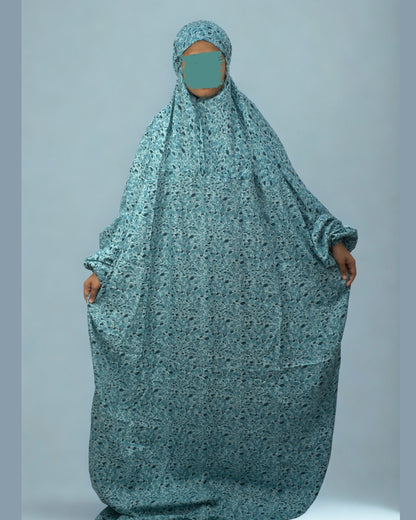 Full view of teal green floral prayer dress with elastic sleeves.