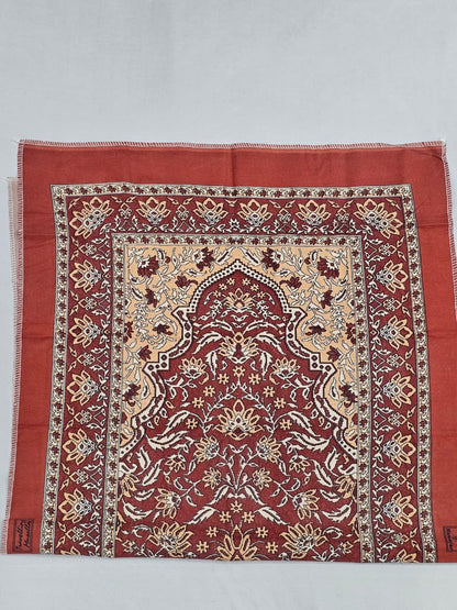 Portable maroon Islamic prayer mat with traditional design.