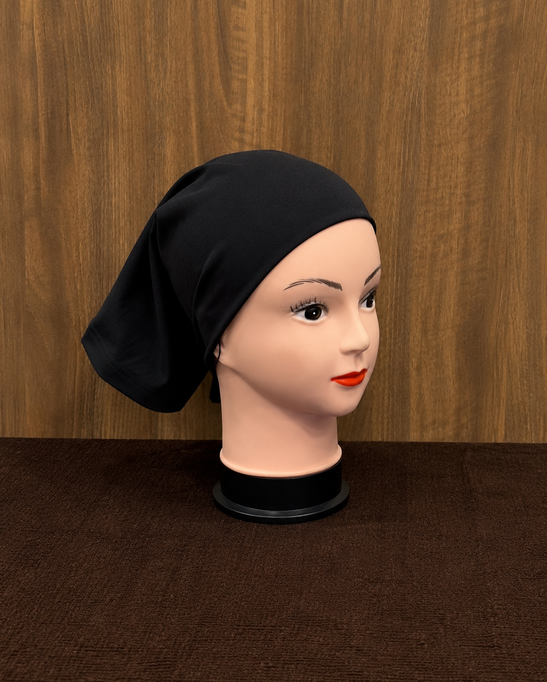 Black tube cap for hijab styling displayed on mannequin