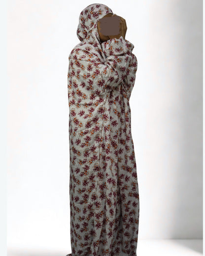 Woman wearing full-length white floral prayer dress with modest coverage.