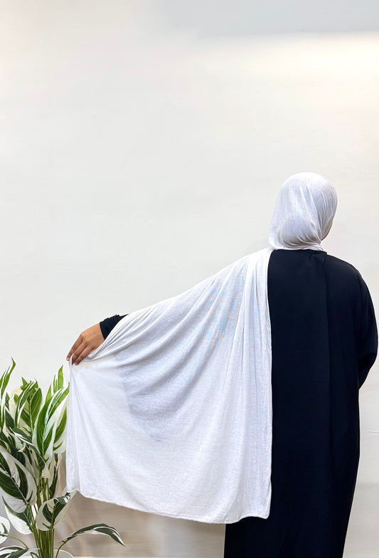 Woman wearing a white jersey hijab, styled casually with soft draping.