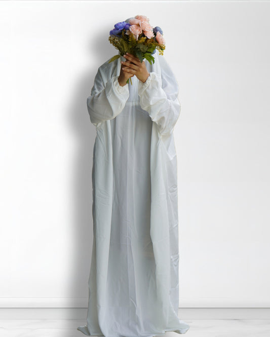 White Islamic prayer dress full length front view with floral bouquet.