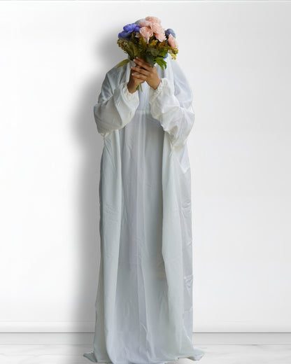 White Islamic prayer dress full length front view with floral bouquet.