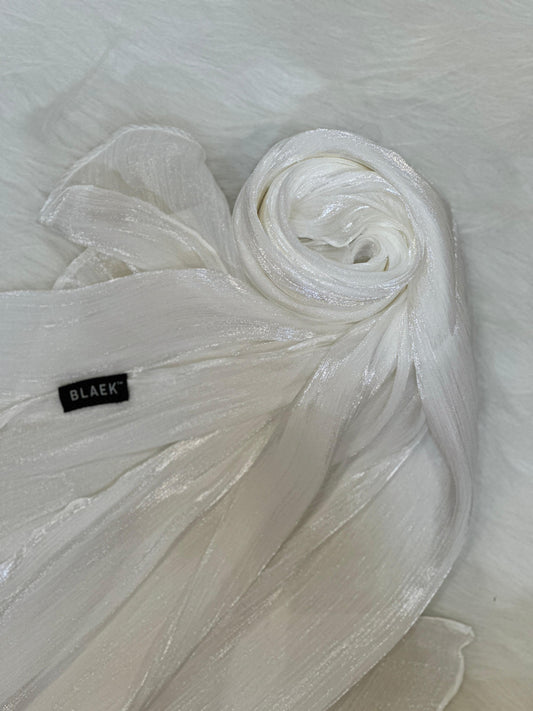 White shimmer hijab coiled into a round swirl, showcasing its delicate shine.