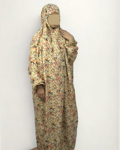 Woman wearing full-length yellow floral polyester lycra prayer dress with modest, relaxed fit.