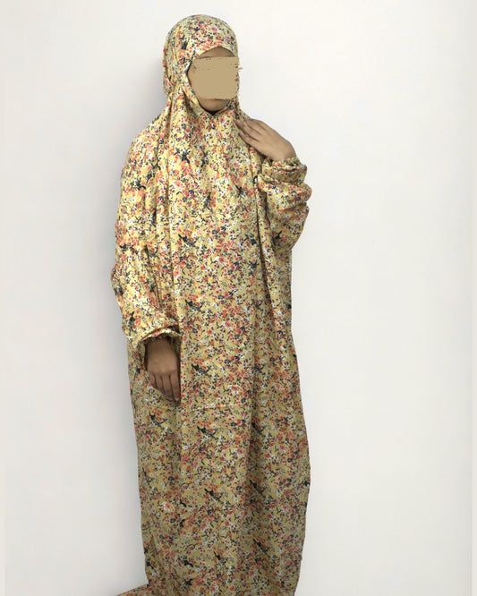 Woman wearing full-length yellow floral polyester lycra prayer dress with modest, relaxed fit.