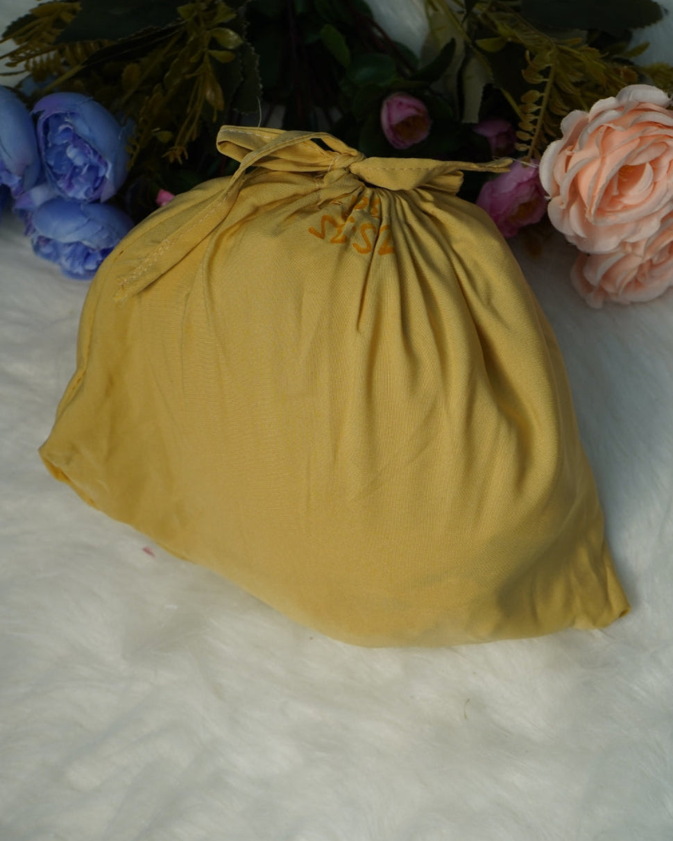 Compact storage pouch included with yellow prayer dress.